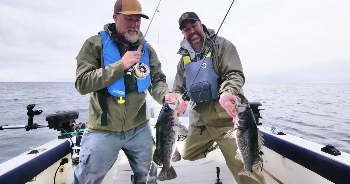 Two anglers on a boat holding black rockfish caught during a fishing trip in the ocean.