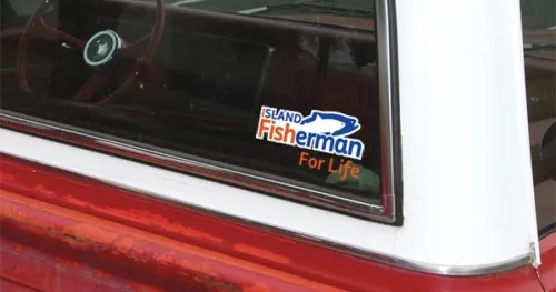 Sticker on a vehicle window displaying 'Island Fisherman For Life' with a fish graphic and a blue and orange color scheme.