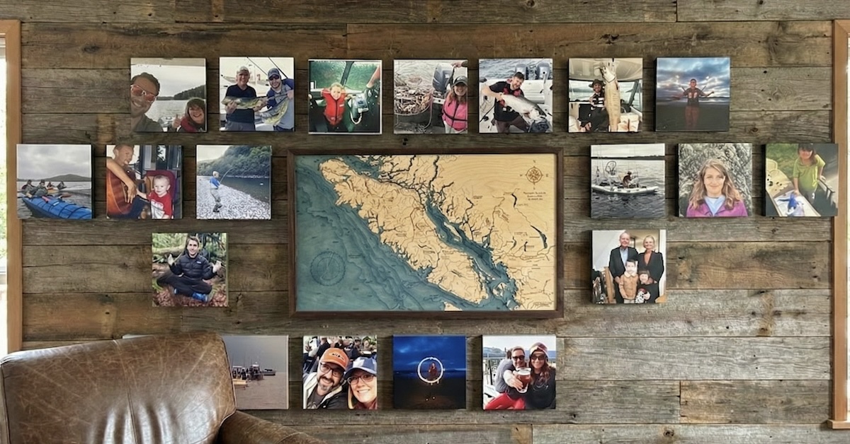 A collection of framed family fishing photos arranged on a wooden wall, with a central map of Vancouver Island.