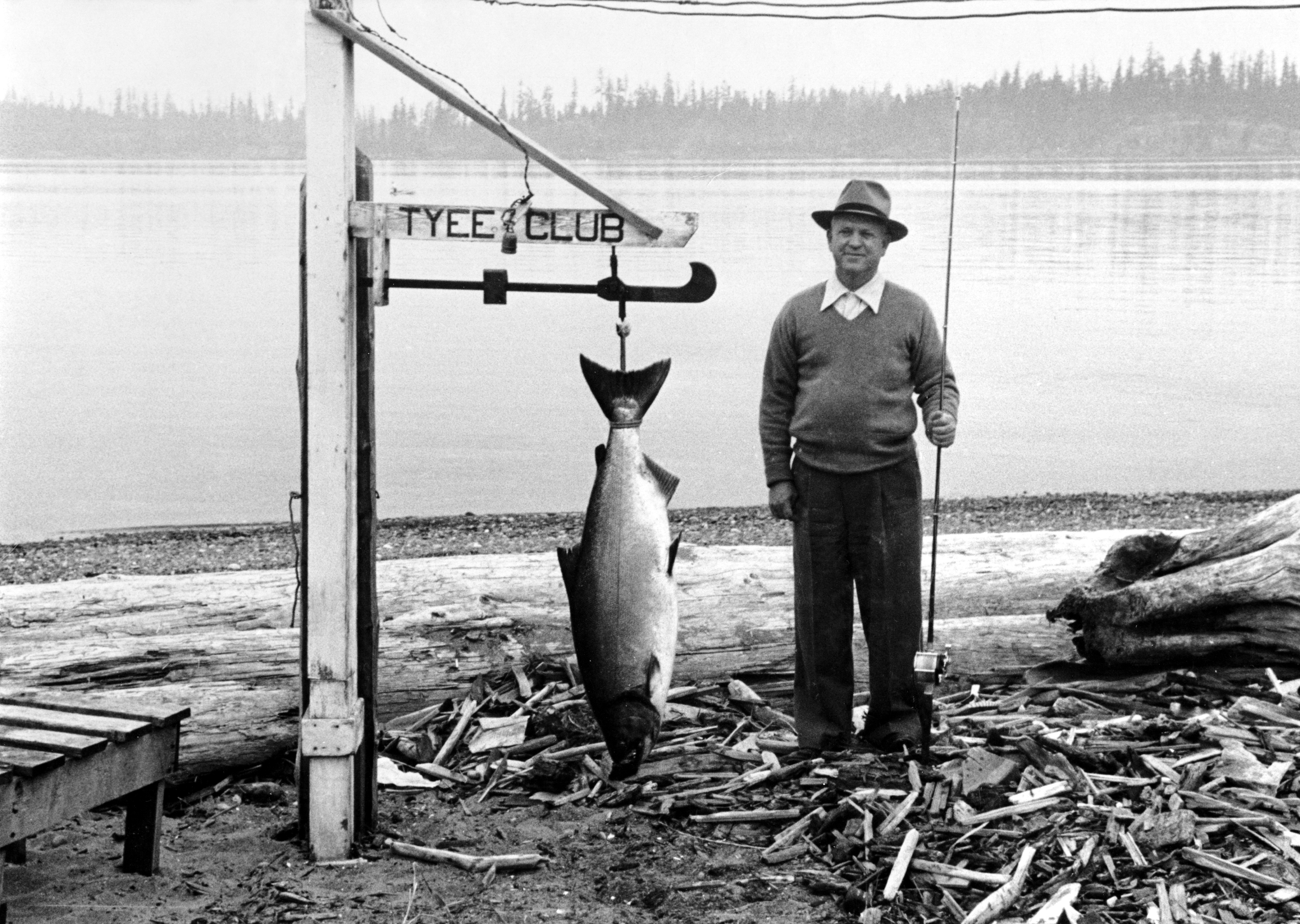 Frank W Pearson of Los Angeles standing beside his 43.5 lb Tyee salmon at the Tyee Club scale in 1938