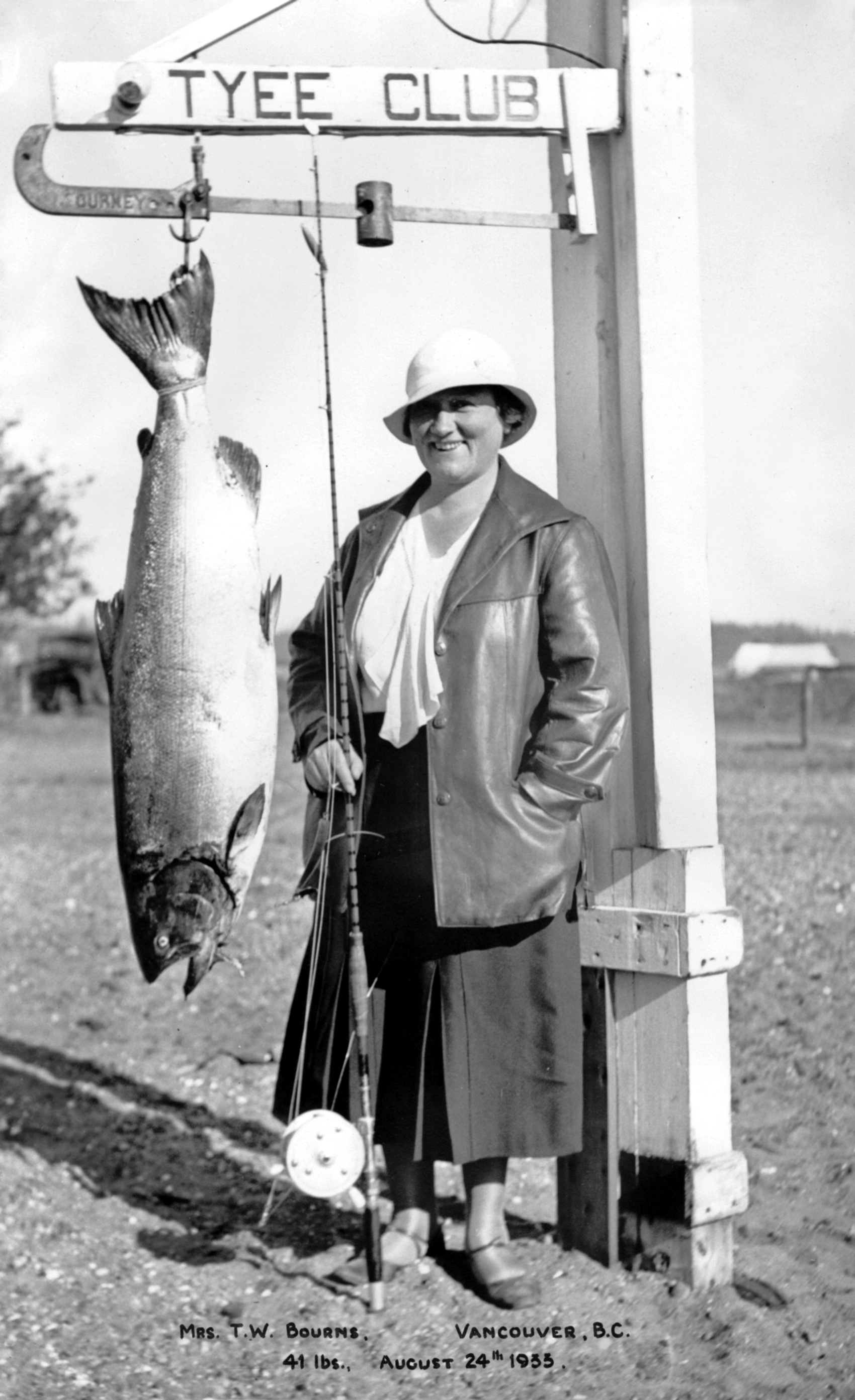 Mrs TW Bourns of Vancouver standing next to her 41 lb Tyee salmon on the Tyee Club scale in 1933