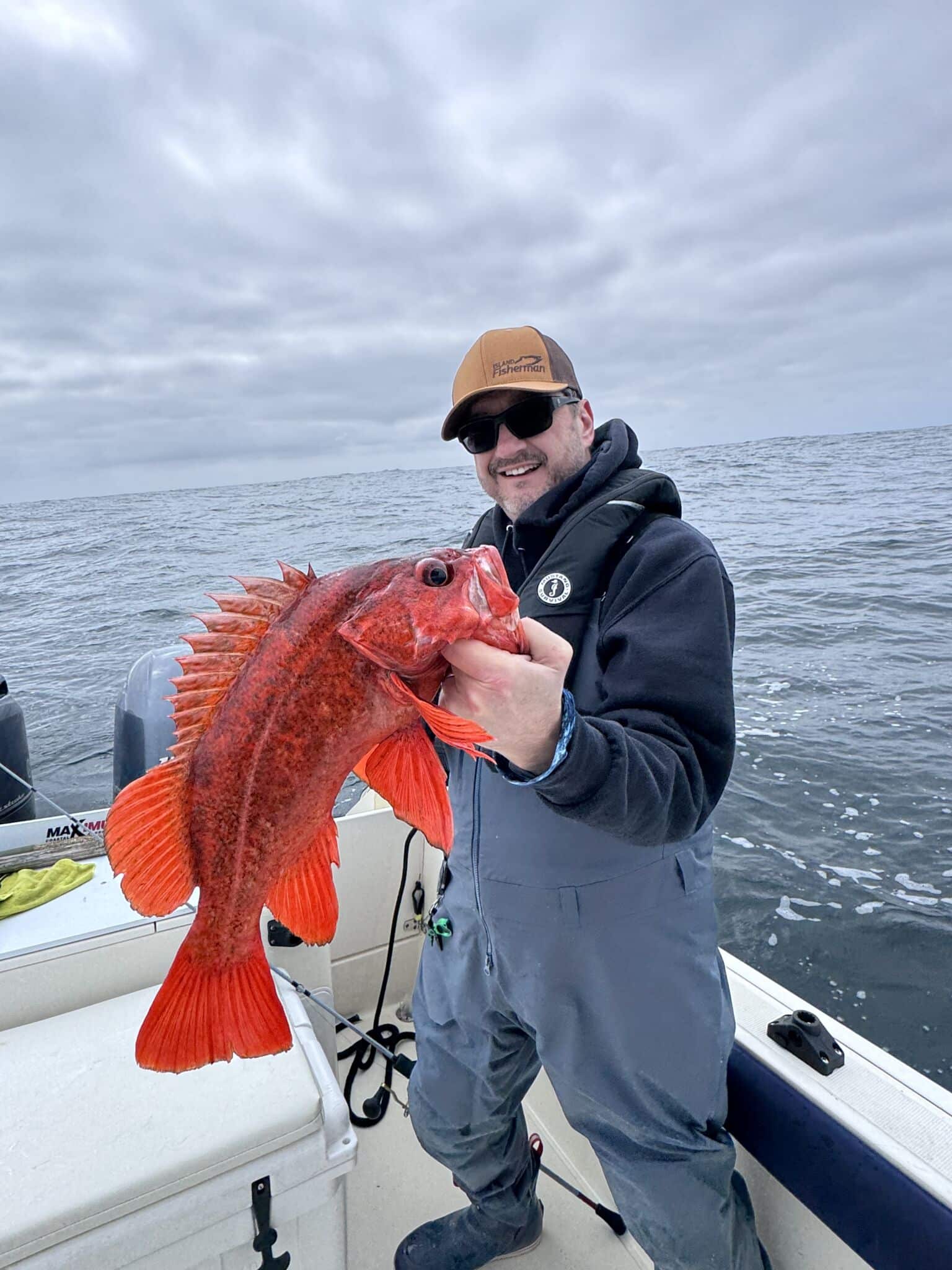 Rockfish Sting Treatment: Myths vs. Hot Water Angler Joel Unickow safely lip-gripping a red rockfish by its lower jaw on a boat
