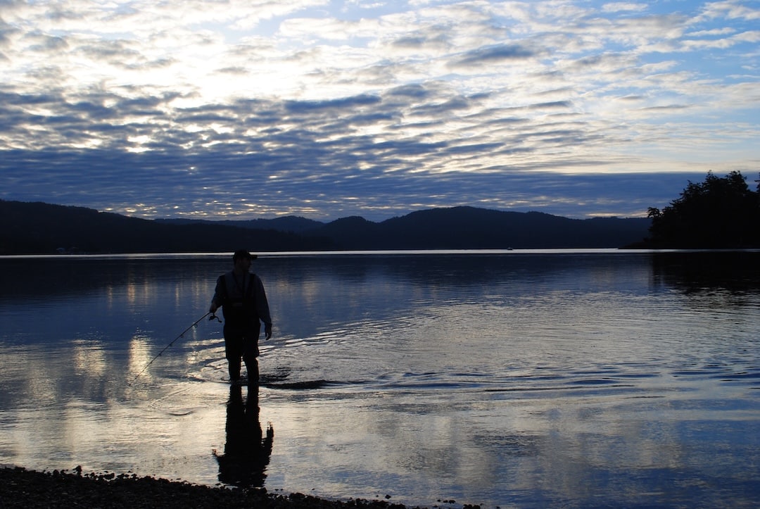 Sooke River Salmon Fishing: Fall Fly Guide & Ethics Angler wading at sunrise during Sooke River salmon fishing in the basin